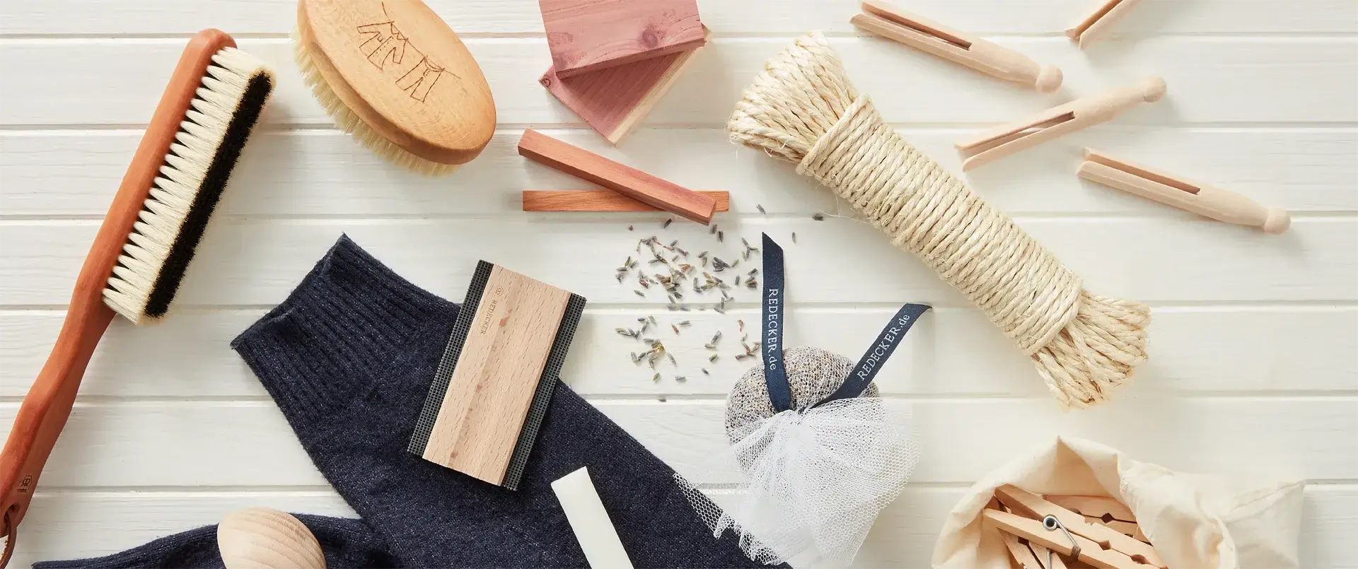 A styled flat-lay of natural fiber cleaning brushes on a white wood plank background | Pretty Clean Shop