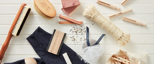 A styled flat-lay of natural fiber cleaning brushes on a white wood plank background | Pretty Clean Shop